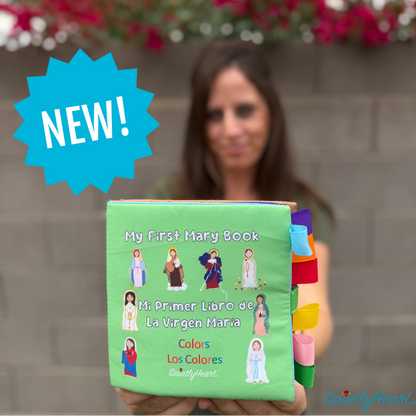 Person holding a colorful children's book titled 'My First Mary Book' with flowers in the background
